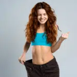 Mulher mostrando a perda de medidas corporais.