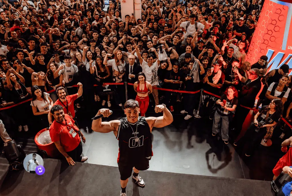 FOTO DO ATLETA GANLEY EM UMA FEIRA DE MUSCULAÇÃO JUNTO COM TODA UMA PLATEIA DE FÃNS